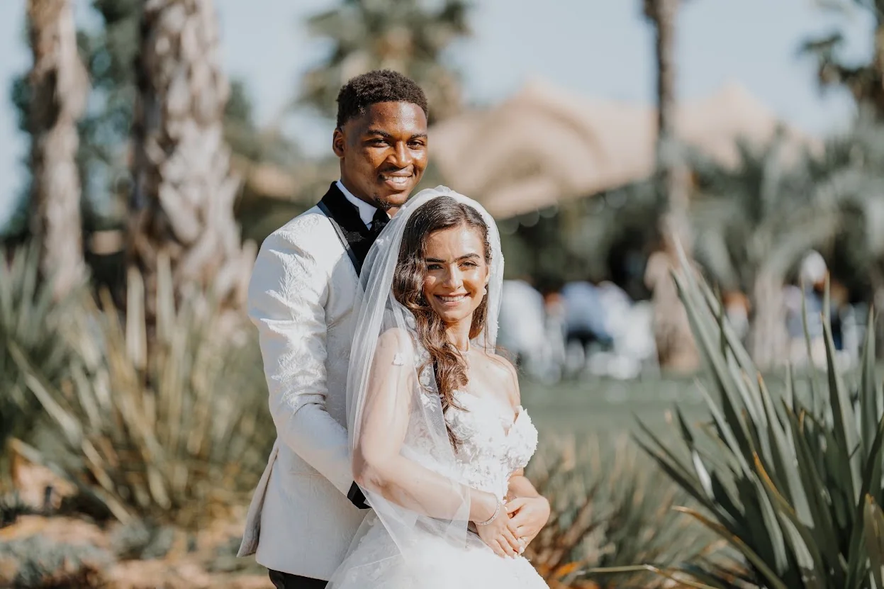 Annaelle et Loïc, souriants, dans un jardin de palmiers