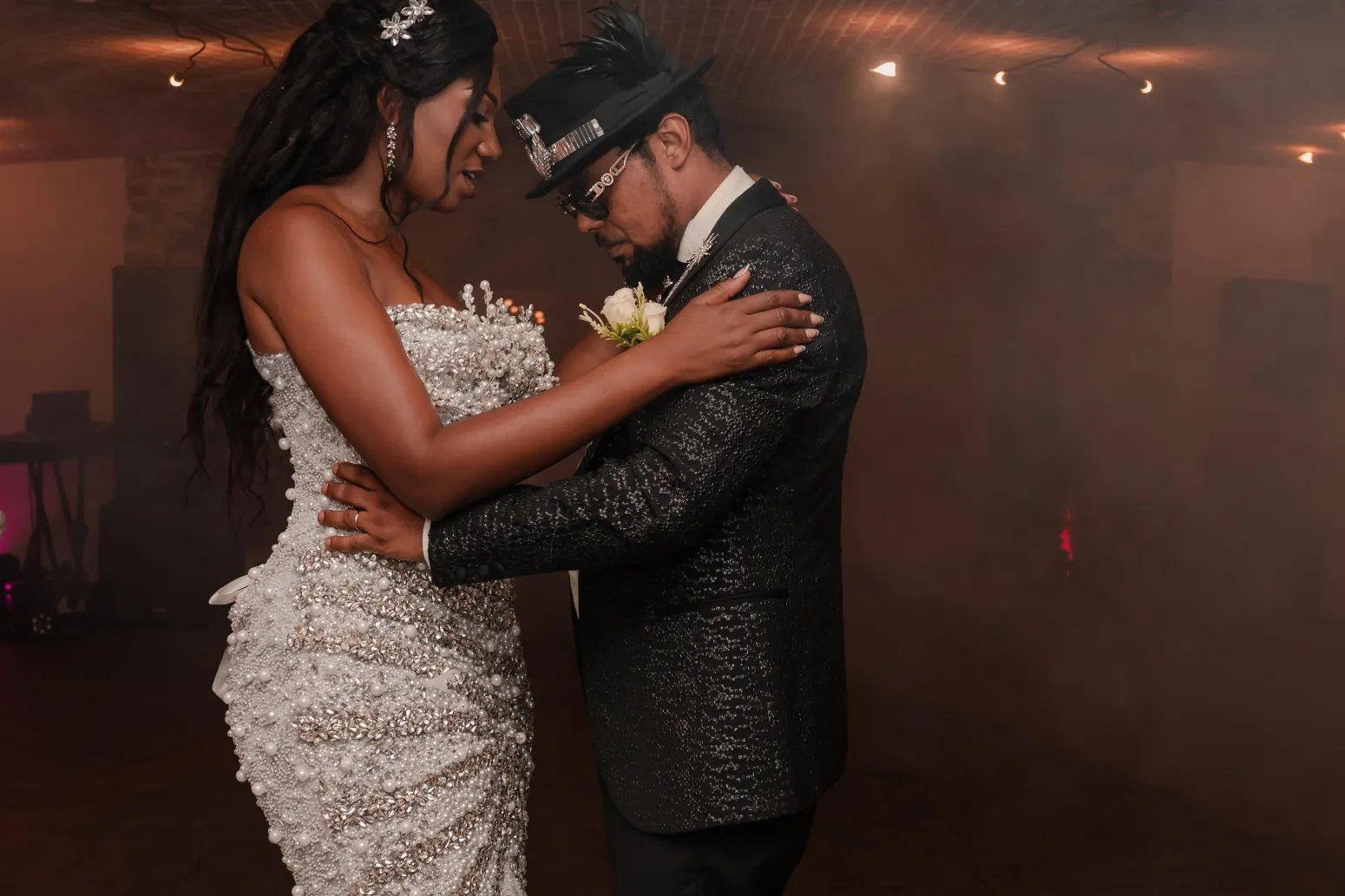 Pendant la soirée, dans une salle voûtée en brique baignée de fumée, Naomie en robe de perles et Patrick en veste noire brodée dansent front contre front