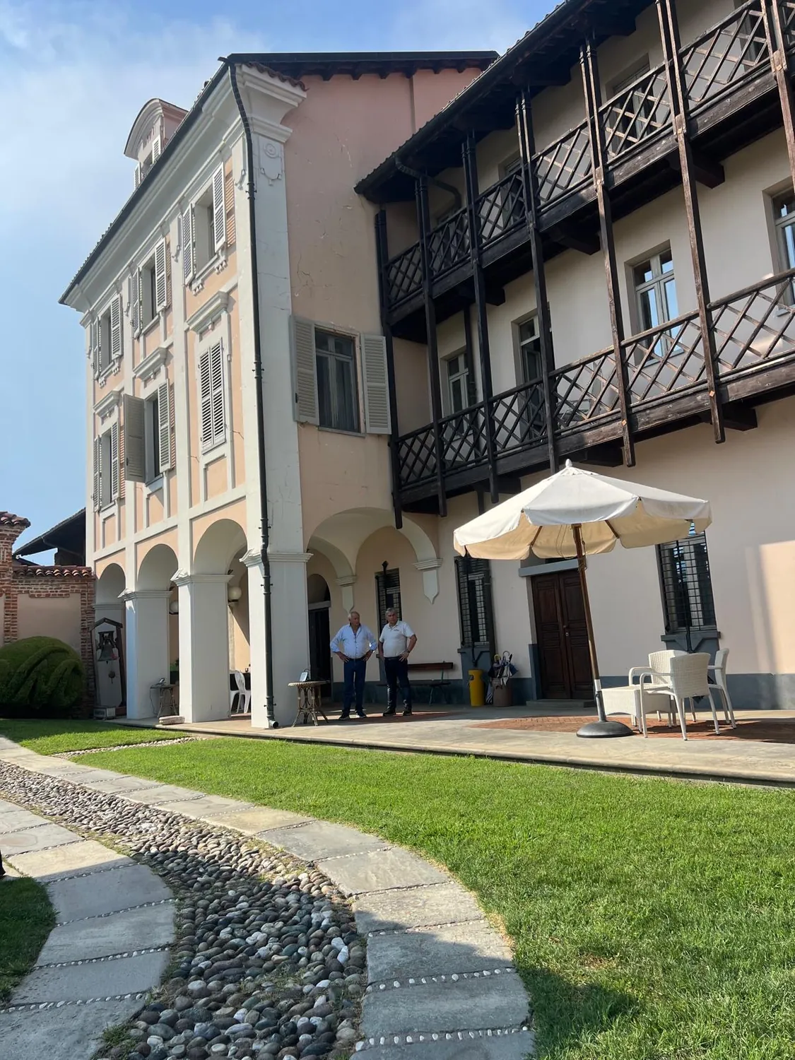 La façade de la Villa Merlin, ses arcades et ses balcons de bois, au-dessus d’une allée de pierre et d’une pelouse